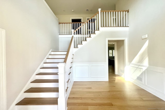 stairs with a high ceiling and hardwood / wood-style flooring