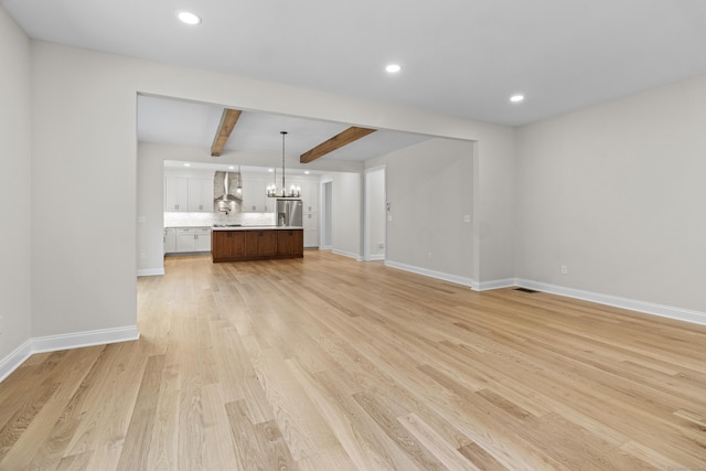 unfurnished living room featuring recessed lighting, a notable chandelier, baseboards, light wood-type flooring, and beam ceiling