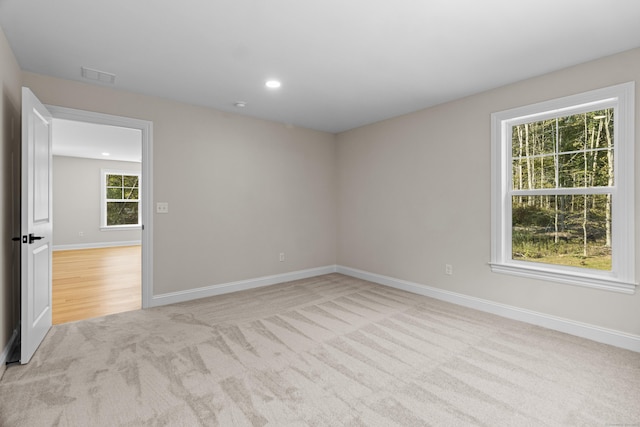 empty room featuring recessed lighting, visible vents, light carpet, and baseboards