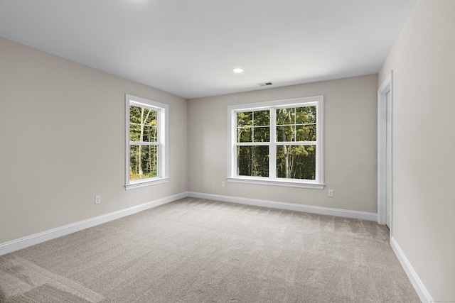 unfurnished room with recessed lighting, carpet flooring, visible vents, and baseboards