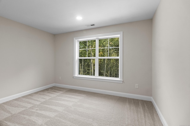 spare room featuring light carpet, baseboards, visible vents, and recessed lighting