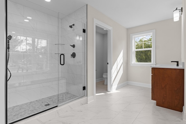 bathroom with a stall shower, baseboards, toilet, marble finish floor, and a sink