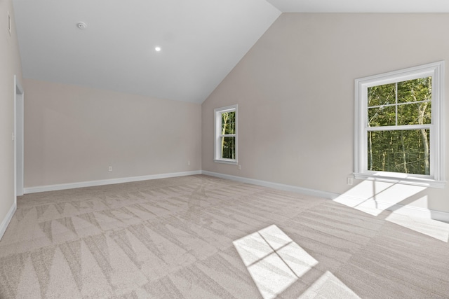 unfurnished room featuring high vaulted ceiling, carpet flooring, and baseboards