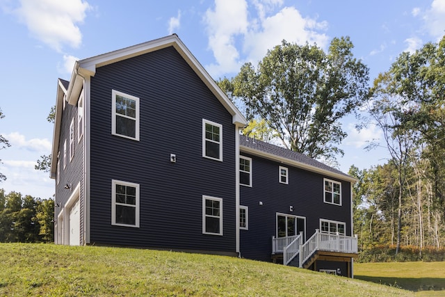 rear view of house with a lawn and a wooden deck