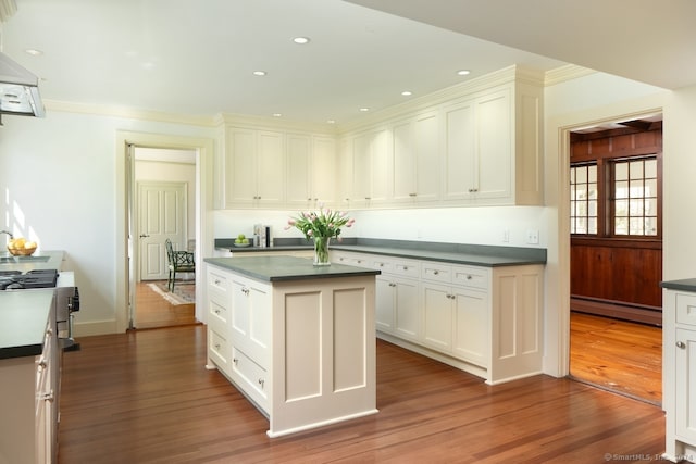 kitchen featuring dark hardwood / wood-style floors, a center island, baseboard heating, and white cabinetry