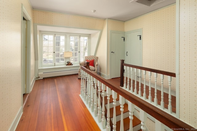 hall featuring a baseboard heating unit and hardwood / wood-style floors