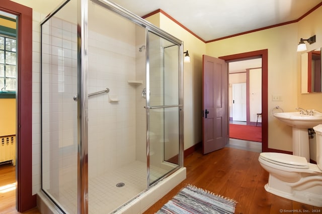 bathroom with ornamental molding, an enclosed shower, and hardwood / wood-style floors