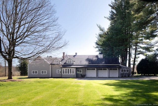 cape cod home with a garage and a front yard