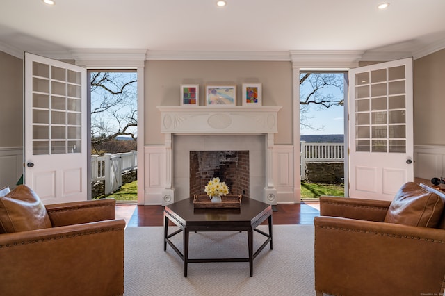 living room with ornamental molding, wood-type flooring, and plenty of natural light