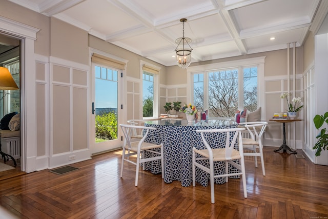 dining room with coffered ceiling, an inviting chandelier, and a healthy amount of sunlight