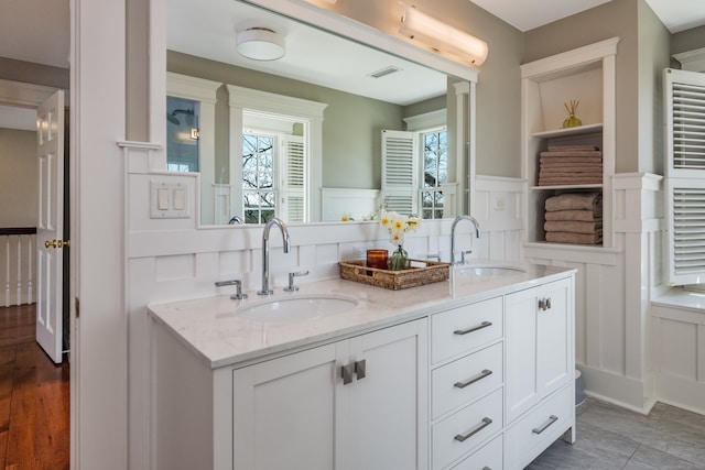 bathroom featuring hardwood / wood-style flooring, tasteful backsplash, and double vanity