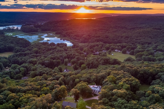 aerial view at dusk featuring a water view