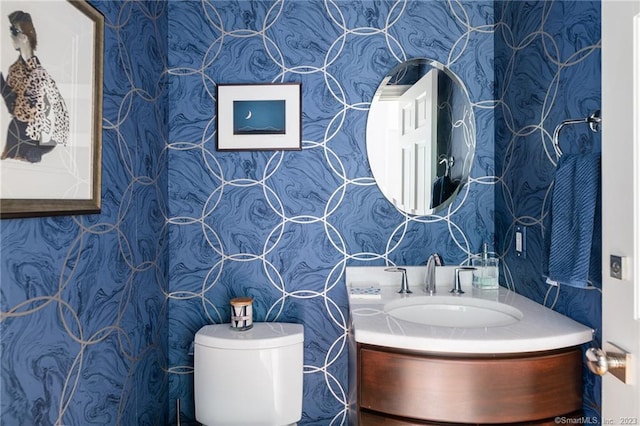 bathroom featuring wallpapered walls, toilet, and vanity