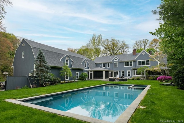 rear view of house featuring a lawn, an outdoor pool, and a gambrel roof