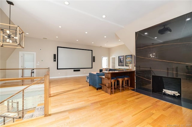 cinema room featuring an inviting chandelier, recessed lighting, wood finished floors, and baseboards