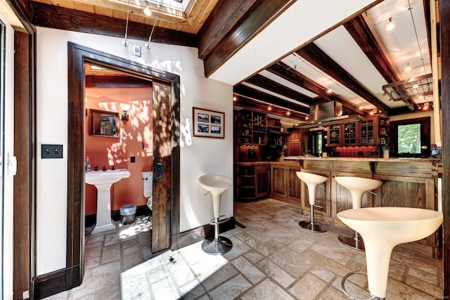 bar featuring beamed ceiling and sink