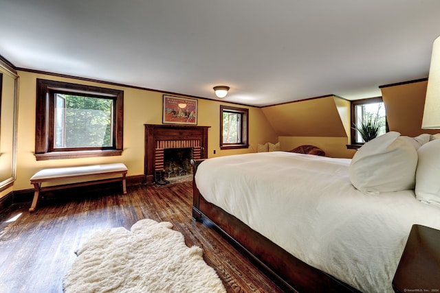 bedroom with a fireplace, dark hardwood / wood-style flooring, and multiple windows