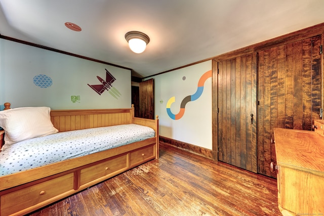 bedroom featuring crown molding and dark hardwood / wood-style floors