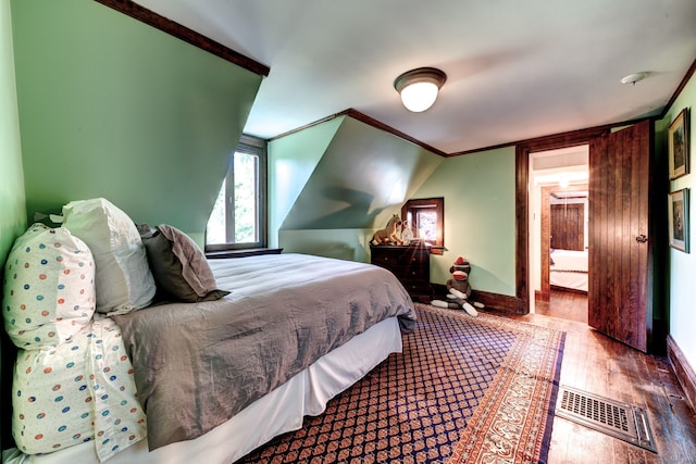 bedroom with hardwood / wood-style flooring and crown molding