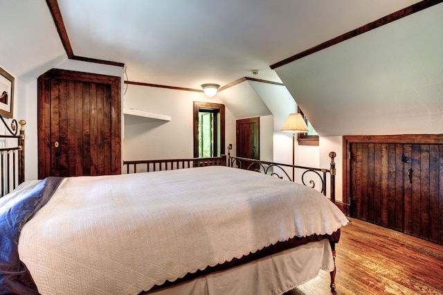 bedroom with vaulted ceiling and hardwood / wood-style floors