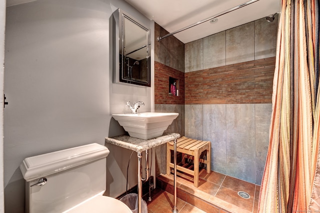 bathroom with toilet, tile patterned floors, walk in shower, and sink