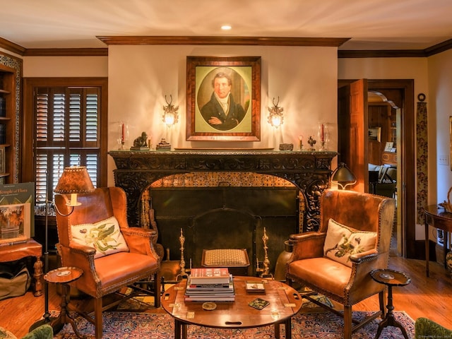 sitting room featuring wood-type flooring, ornamental molding, and a high end fireplace