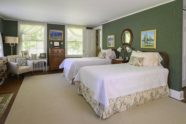 bedroom with crown molding, radiator heating unit, and hardwood / wood-style flooring