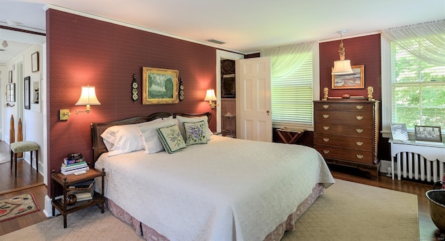 bedroom with radiator and hardwood / wood-style flooring