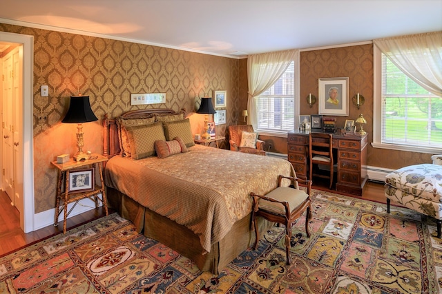 bedroom featuring a baseboard radiator, ornamental molding, and hardwood / wood-style floors