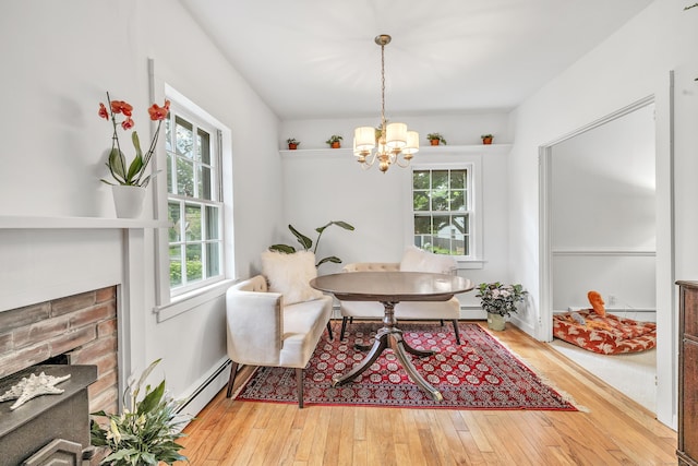 dining space featuring plenty of natural light, baseboard heating, a chandelier, and light hardwood / wood-style flooring