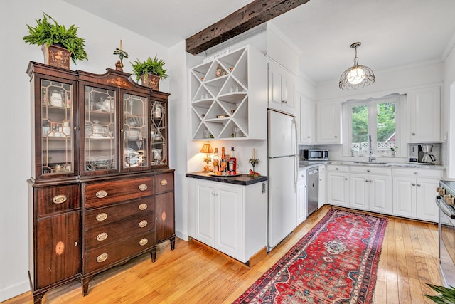 kitchen featuring sink, stainless steel appliances, light hardwood / wood-style floors, decorative light fixtures, and white cabinets