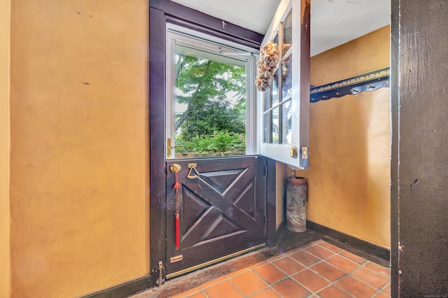 doorway to outside with tile patterned flooring