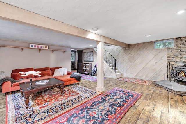 living room featuring wood-type flooring, a wood stove, and wood walls