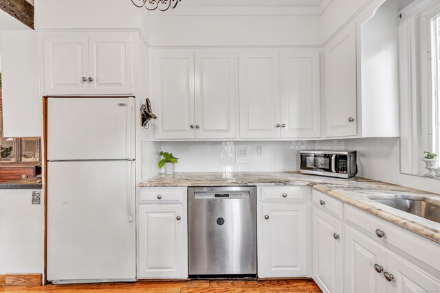 kitchen featuring decorative backsplash, light stone countertops, white cabinetry, and appliances with stainless steel finishes