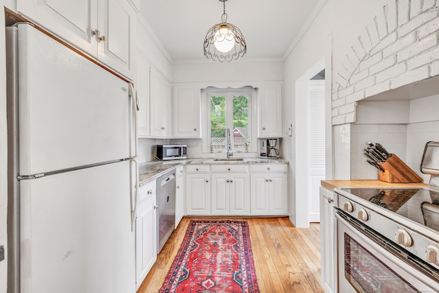 kitchen featuring tasteful backsplash, stainless steel appliances, sink, white cabinets, and hanging light fixtures