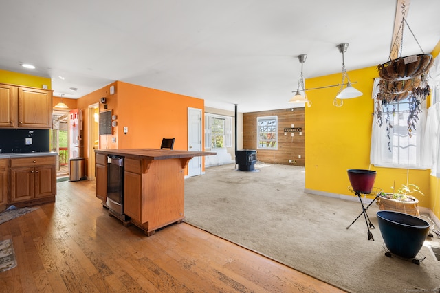 kitchen featuring decorative light fixtures, beverage cooler, a kitchen island, wood-type flooring, and a breakfast bar