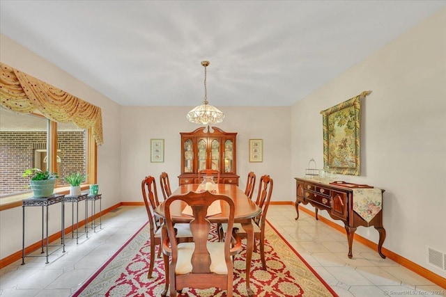 dining space with light tile patterned floors and an inviting chandelier