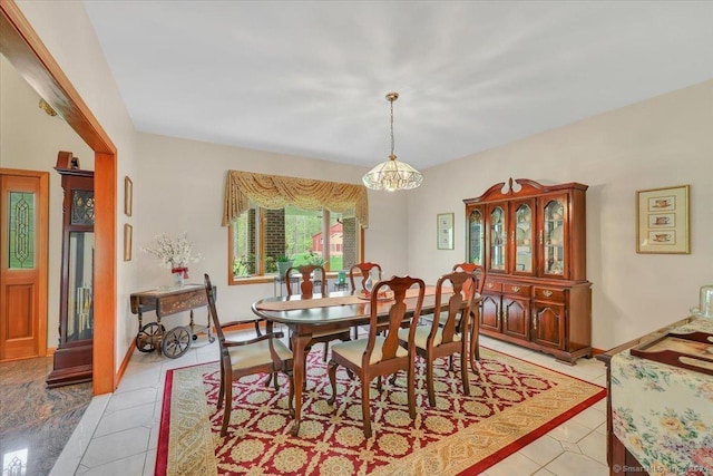 dining area featuring light tile patterned flooring and an inviting chandelier