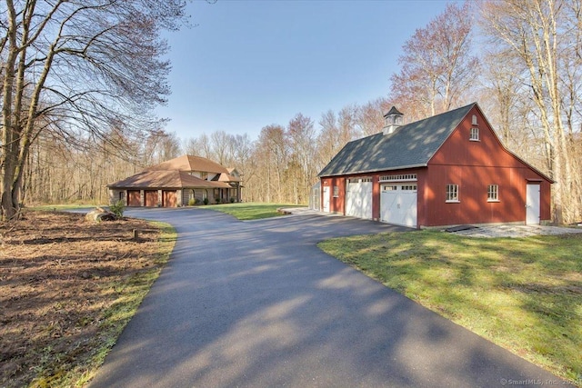 view of property exterior with an outdoor structure and a yard