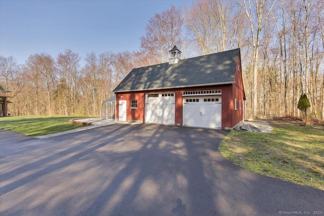 view of home's exterior featuring a lawn, an outdoor structure, and a garage