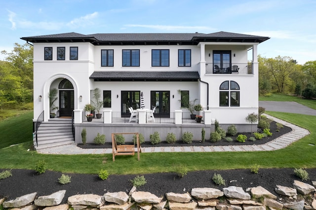 view of front of property featuring a front yard and a balcony