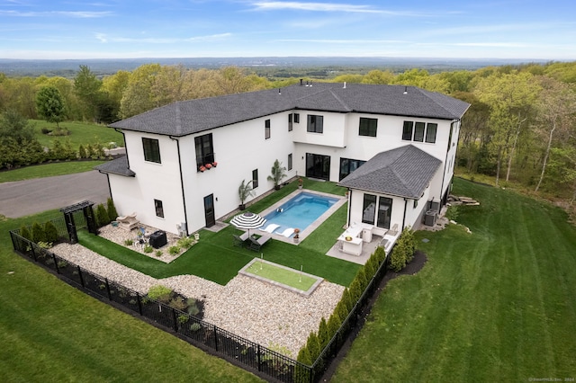 back of house with a patio, a lawn, and a fenced in pool