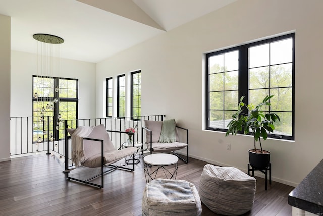 living area featuring a healthy amount of sunlight, dark hardwood / wood-style flooring, and lofted ceiling