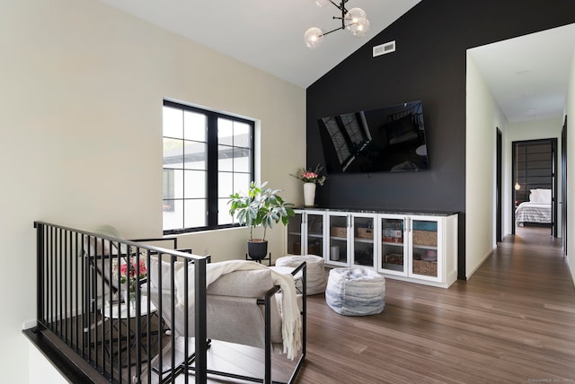 living room with an inviting chandelier, dark hardwood / wood-style flooring, and vaulted ceiling