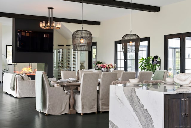 dining space featuring a chandelier, french doors, dark wood-type flooring, and vaulted ceiling with beams