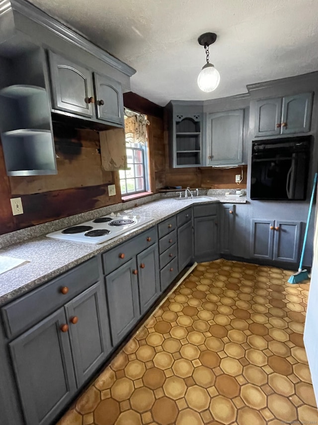 kitchen featuring gray cabinetry, sink, pendant lighting, white electric cooktop, and black oven