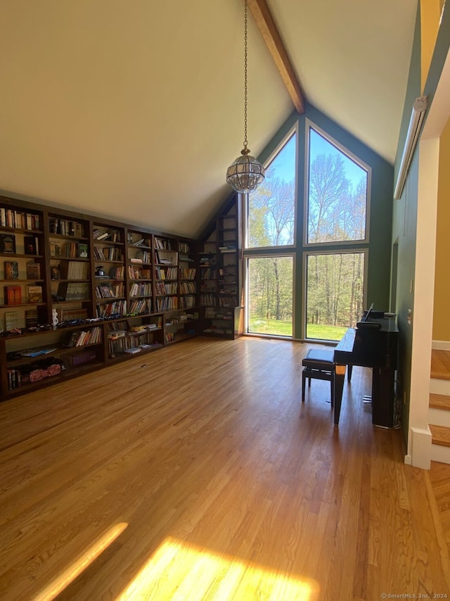 unfurnished living room featuring hardwood / wood-style flooring, beam ceiling, and high vaulted ceiling