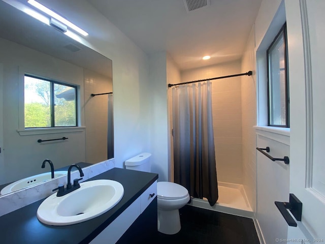 bathroom featuring walk in shower, toilet, and vanity