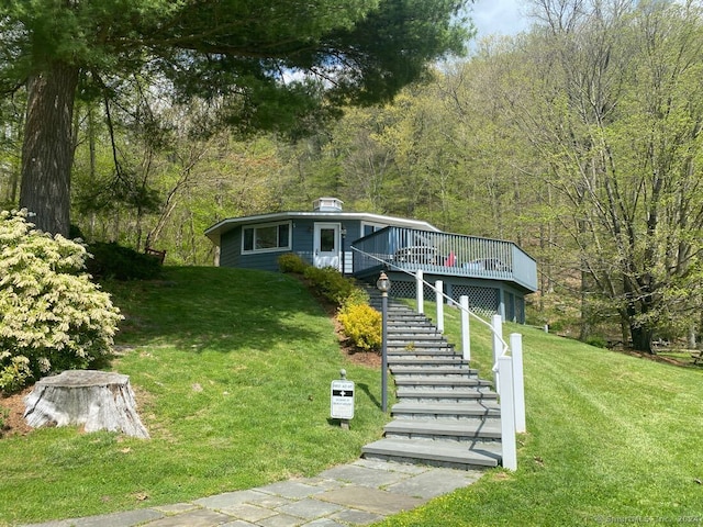 view of front of property with a front yard and a wooden deck