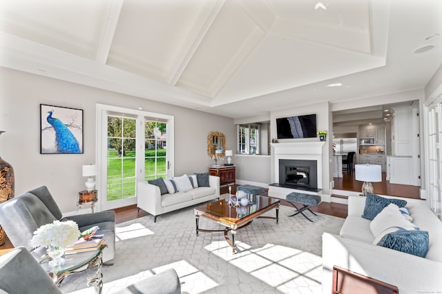 living room featuring vaulted ceiling, hardwood / wood-style flooring, and french doors